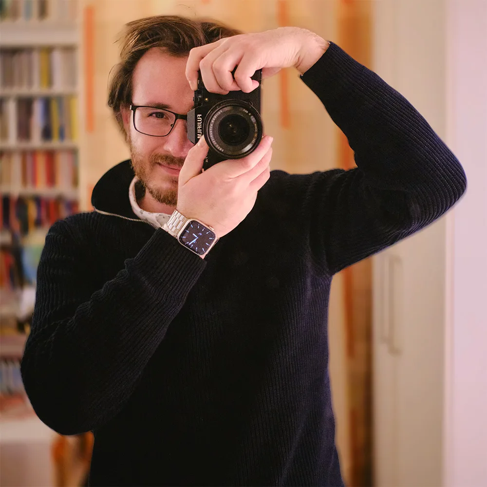 Portrait of Christoph Dethloff holding a camera